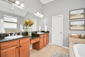 La salle de bains est pourvue de 2 lavabos et d'un grand miroir. dans l'établissement 3BR 3Ba Upscale Luxury Home in The Heights, à Houston