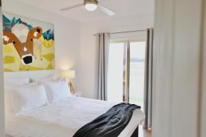 Cygnet RiverDusty's Run - Escape. Relax. Explore.的白色卧室的墙上挂着牛油画