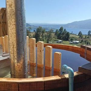 a swimming pool with a fence and a pole at Lomas de Riñihue para 2p in Valdivia