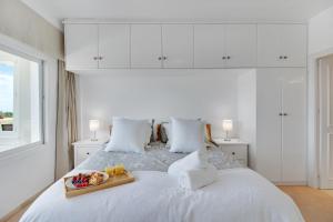 Una cama blanca con una bandeja de fruta. en Lujoso apartamento con alucinantes vistas al golf - Iwii A 38, en Marbella