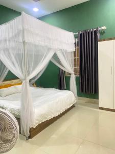 1 dormitorio con 1 cama con dosel en Mon House en Bao Loc