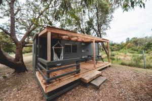a tiny house on a trailer in a field at Tathra Beach Eco Camp in Tathra