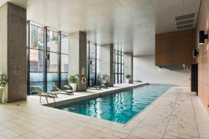 a swimming pool in a building with windows at Sakura Serviced Apartments in Melbourne