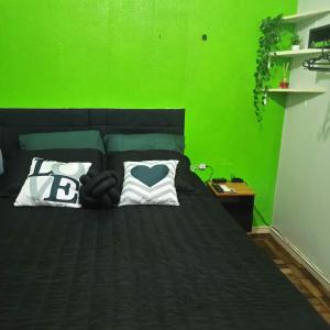 Dormitorio verde con cama y pared verde en Amplo apt próximo ao Consulado, en Porto Alegre