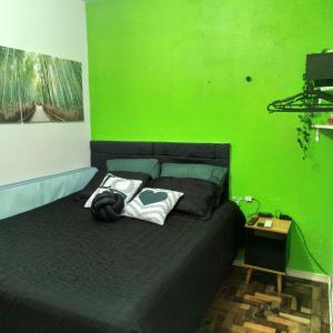 a green bedroom with a bed with a green wall at Amplo apt próximo ao Consulado in Porto Alegre