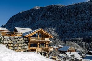 ein Blockhaus im Schnee vor einem Berg in der Unterkunft Chalet Grand-Duc in Montriond