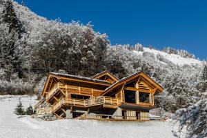 eine Blockhütte im Schnee mit Bäumen in der Unterkunft Chalet Grand-Duc in Montriond