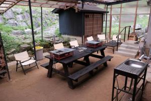 um pátio com uma mesa e cadeiras e um edifício em 一軒家貸切 ARUYOguesthouse BBQと焚き火ができる宿 