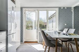 a kitchen and dining room with a table and chairs at Pleasant cottage on Oland with a panoramic view of Kalmarsund in Degerhamn