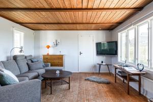 a living room with a couch and a tv at Pleasant cottage on Oland with a panoramic view of Kalmarsund in Degerhamn