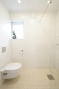 een witte badkamer met een toilet en een douche bij Papli Beach Apartment in Pärnu
