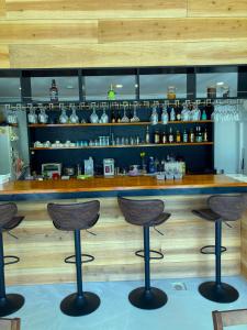 a bar with three stools in front of a counter at Nakijin Resort Guest House in Nakijin