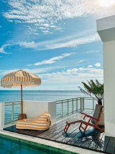 einen Pool mit einem Sonnenschirm, einem Stuhl und einem Tisch in der Unterkunft Renjana Beach House in Bira + 37 Fotos