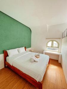 a bedroom with a large bed with a green wall at Renjana Beach House in Bira