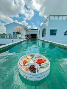 ein Tablett mit Speisen im Wasser in einem Pool in der Unterkunft Renjana Beach House in Bira