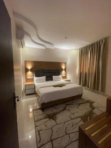 a bedroom with a large bed with a stone wall at Orient House in Hail