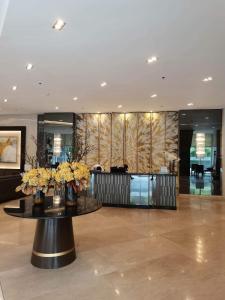 un vestíbulo con una mesa con flores. en Fame Residences T1 Family Suite 1507 en Manila