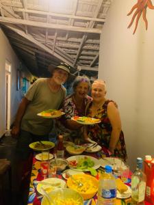 Un groupe de personnes assises à une table avec des assiettes de nourriture dans l'établissement Sun Shine Guest House, à Negombo