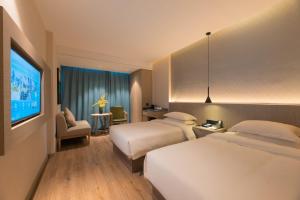 Un pat sau paturi într-o cameră la 义乌曼卡兰酒店国际商贸城店Yiwu kaiding Hotel