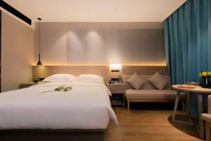 Un pat sau paturi într-o cameră la 义乌曼卡兰酒店国际商贸城店Yiwu kaiding Hotel