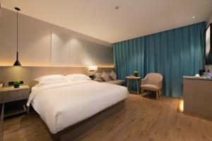 Un pat sau paturi într-o cameră la 义乌曼卡兰酒店国际商贸城店Yiwu kaiding Hotel