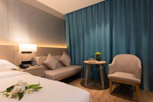 Un pat sau paturi într-o cameră la 义乌曼卡兰酒店国际商贸城店Yiwu kaiding Hotel
