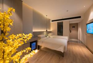 Un pat sau paturi într-o cameră la 义乌曼卡兰酒店国际商贸城店Yiwu kaiding Hotel