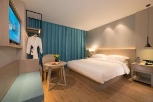 Un pat sau paturi într-o cameră la 义乌曼卡兰酒店国际商贸城店Yiwu kaiding Hotel