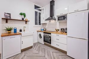 バルセロナにあるSweet Inn - Urgellの白い家電製品が備わるウッドフロアのキッチン