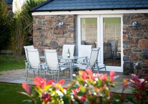 a patio with a table and chairs in a yard at Jennys Cottage in Abersoch