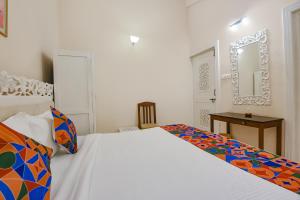 a bedroom with a white bed and a mirror at FabHotel Prime Pool Point Highland, Candolim Beach in Candolim