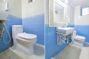 uma casa de banho azul com um WC e um lavatório em FabHotel Prime Pool Point Highland, Candolim Beach em Candolim