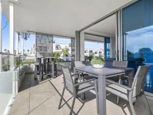 comedor con mesa y sillas en el balcón en Elysee Beachside Apartments Alexandra Headland, en Alexandra Headland