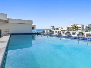 una gran piscina de agua azul en un edificio en Elysee Beachside Apartments Alexandra Headland, en Alexandra Headland