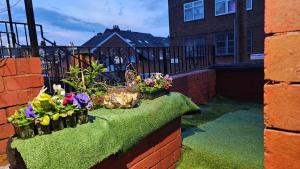 a garden with flowers on a brick wall at Beautiful En-suite Studio in Leeds -Lower Floor in Leeds