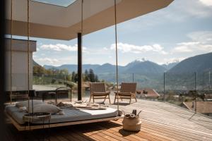 a bed on a deck with a view of mountains at Villa Goyen in Schenna