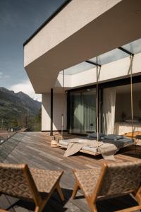 a house with a deck with two chairs at Villa Goyen in Schenna