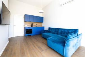 什文托伊的住宿－THE BEST OF ŠVENTOSIOS VARTAI, By Cohost，一间带蓝色沙发的客厅和一间厨房