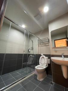 a bathroom with a shower and a toilet and a sink at 宜蘭包棟民宿 嵐恬苑 歡唱 電動麻將 燒烤 in Yilan City