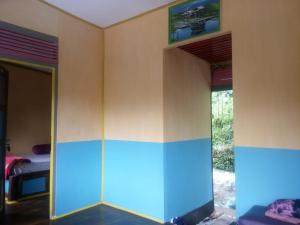 a room with two doors and a bed in it at Bamboo Park & Resort Malino in Malino