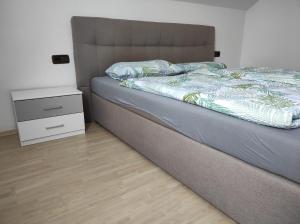 1 dormitorio con cama y mesita de noche en Appartement Illertal, nähe A7 , Legoland, 2 Schlafzimmer en Vöhringen