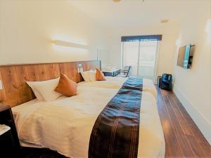 a bedroom with a large bed with a wooden headboard at LiVEMAX RESORT Izu Shimoda in Shimoda