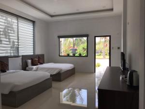 ein Schlafzimmer mit 2 Betten und einem TV in der Unterkunft Green Star Premium Resort - Mui Ne - Formerly Hung Thinh Resort in Ấp Long Sơn