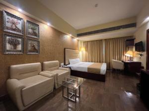 a hotel room with a bed and a couch at Hotel O2 Oxygen in Kolkata