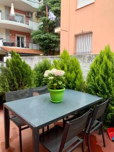 une table verte avec des chaises et un vase sur elle dans l'établissement MAMA apt & parking, à Larissa