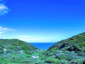 uma vista para o oceano entre duas montanhas em LiVEMAX RESORT Izu Shimoda em Shimoda