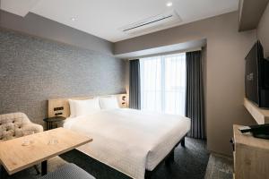 a hotel room with a large bed and a window at Tokyu Stay Shibuya in Tokyo