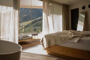 sypialnia z łóżkiem i dużym oknem w obiekcie Villa Goyen w mieście Schenna