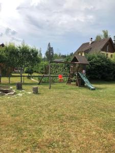 een park met een speeltuin met een glijbaan en een glijbaan bij CHATA ORAVSKA PRIEHRADA in Námestovo