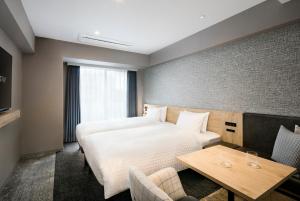 a hotel room with a bed and a table at Tokyu Stay Shibuya in Tokyo